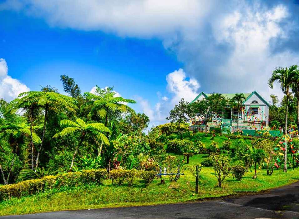 lush green hillside with a house on top of it | Emeraldsuites